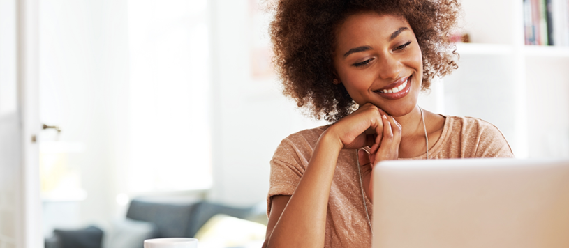 Woman smiling at her laptop computer.